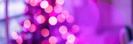 Colorful bokeh lights create a festive atmosphere near a beautifully decorated Christmas tree at nightの素材