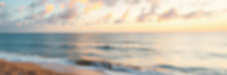 Evening sunset casts warm colors over calm ocean waters by the beach in a serene landscapeの素材