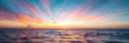 Beautiful sunset over the ocean with colorful clouds and serene water reflections in warm tonesの素材