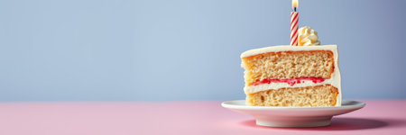 Celebration cake with a lit candle on a pink table against a blue backgroundの素材
