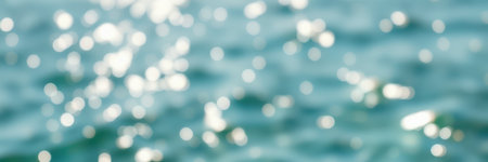 Bright sunlight reflecting on rippling water creates a mesmerizing bokeh effect in this tranquil seaside viewの素材