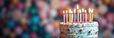 Birthday cake with lit candles surrounded by colorful decorations in a festive setting during a celebrationの素材