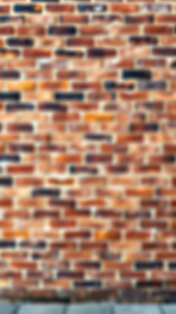 Brick wall background featuring varied texture and warm tones in an urban setting during daylight hoursの素材