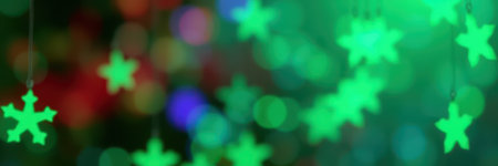 Festive green snowflakes create a vibrant holiday atmosphere with colorful lights in the backgroundの素材