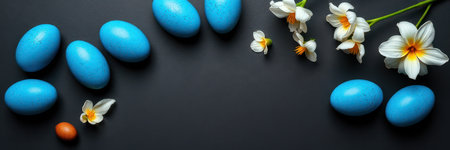 Colorful blue and brown eggs arranged with delicate flowers on a dark surface for a spring celebrationの素材