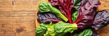 Freshly harvested Swiss chard leaves arranged on a wooden surface for healthy meal preparationの素材
