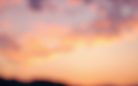 Beautiful pastel sunset with gentle hues reflecting in the sky over a distant horizon during twilightの素材