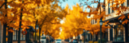 Autumn streets lined with vibrant yellow trees in a quaint neighborhood during a sunny dayの素材
