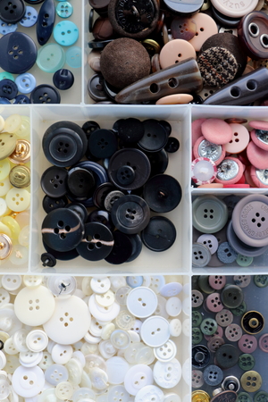 buttons for clothing in a box sorted by color and sizeの写真素材