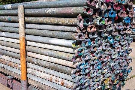 Scaffolding pipes piled up in a storage and ready for use to build a new industrial construction,...
