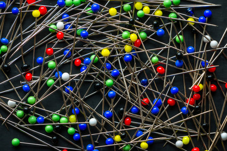 A bunch of multi colored round head pins on a black background