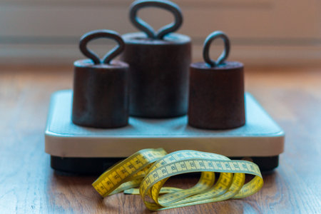 Checking weight on a scale and measure your size, being over weighted is very unhealthyの写真素材