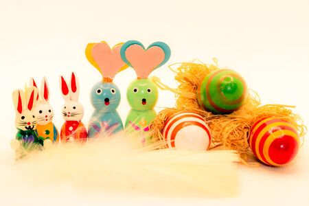 A symbol of the Easter celebration, with Easter bunnies and Easter eggs and white feathers, to be used as wallpaper or postcardの写真素材