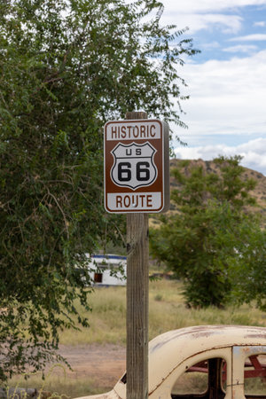 A route 66 sign posted on the side of the highway on America's historic east-west route.の写真素材