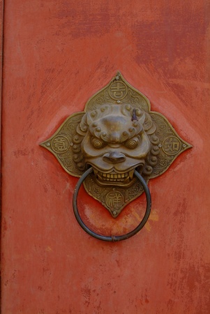 Chinese vintage lion knocker on red doorの写真素材