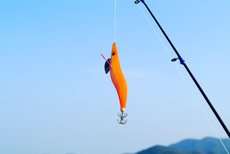 Fish hook in shape of red fish.の写真素材