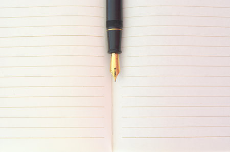Closeup photo of notebook with old golden ink penの写真素材