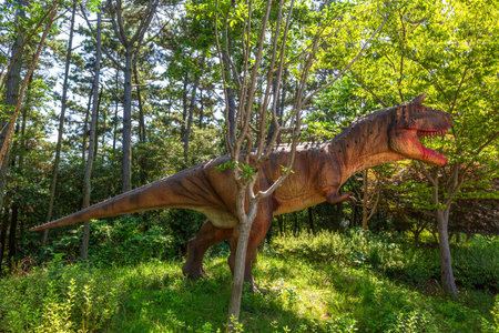 a view of a forest park with dinosaur sculptures