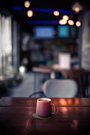 latte coffee in a mug on a wooden tableの写真素材