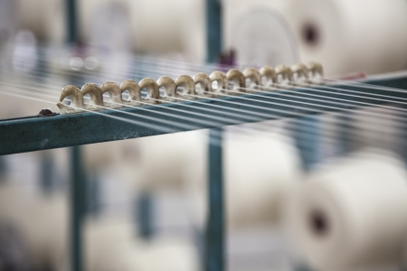 cotton threads coming out from multiple small cotton reel cone and combined together for weavingの写真素材