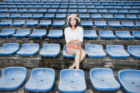 asian female siting in the campus stadium with casual clothesの写真素材