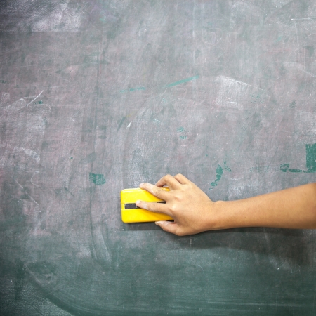 hand with blackboard eraser cleaning blackboardの写真素材