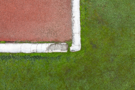 green grass field next to the red rubber fieldの写真素材