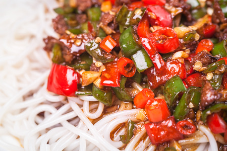 chinese rice noodle with red and green chili sauce stir fried with beef, a popular chinese dishの写真素材