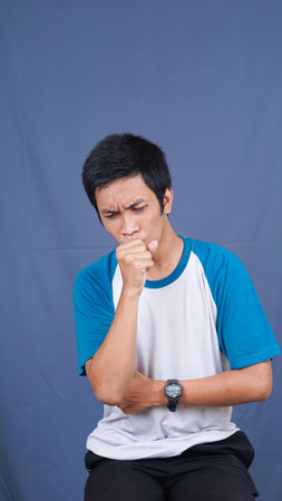 asian man cough isolated with blue backgroundの写真素材
