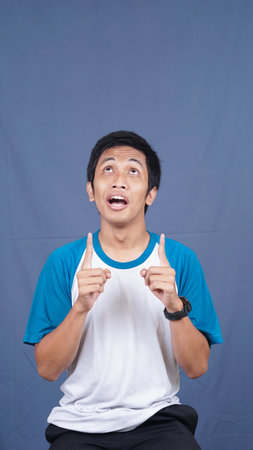asian man pointing to top spaceの写真素材