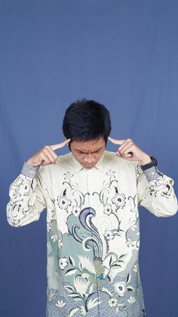 asian man thinking and get some idea with batik clothesの写真素材