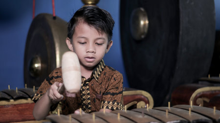 Asian kids playing the Gamelan with batik clothes. Gamelan is a musical instrument typical of Indonesia, Central Javaの写真素材