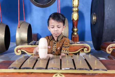 Asian kids playing the Gamelan with batik clothes. Gamelan is a musical instrument typical of Indonesia, Central Javaの写真素材