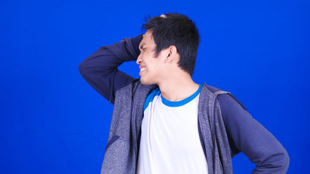 asian man wearing headache jacket  isolated blue background
