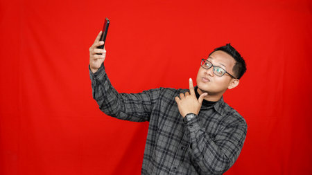 Funny Asian man taking photo selfie with smartphone