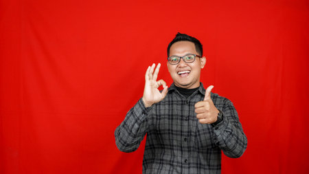 Happy Asian man shows thumb up for success concept