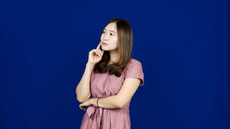beautiful asian woman thinking and get idea isolated blue background