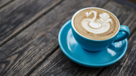 coffeelatte with blue cup and goose draw in topping