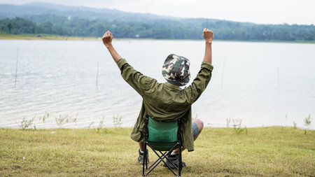traveller man sit down on the reservoir and success gestureの写真素材