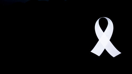 A white awareness ribbon on black background for peace conditionの写真素材