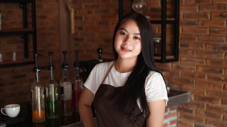 Asian woman barista smilling look camera at cafe