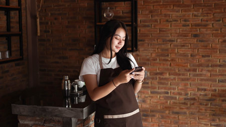 Asian Women Barista smiling and holding phone. Check online order from customer.