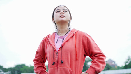 Asian women rest after running. wearing jacket and earphoneの写真素材