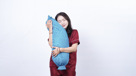 Beautiful Asian woman with pillow on white backgroundの写真素材
