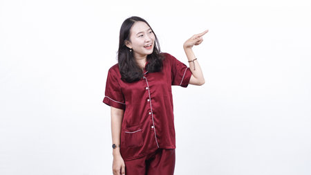 woman wearing pajama pointing blank space isolated white backgroundの写真素材
