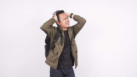 Asian man wearing bag confused and frustased white backgroundの写真素材