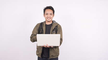 The young man wearing bag
on a white background with laptopの写真素材