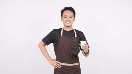 The man wearing the apron stands on a white background holding a glassの写真素材