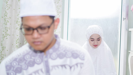 a Muslim family consisting of parents and children perform greeting movements during prayerの写真素材