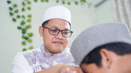 a Muslim family consisting of parents and children perform greeting movements during prayerの写真素材